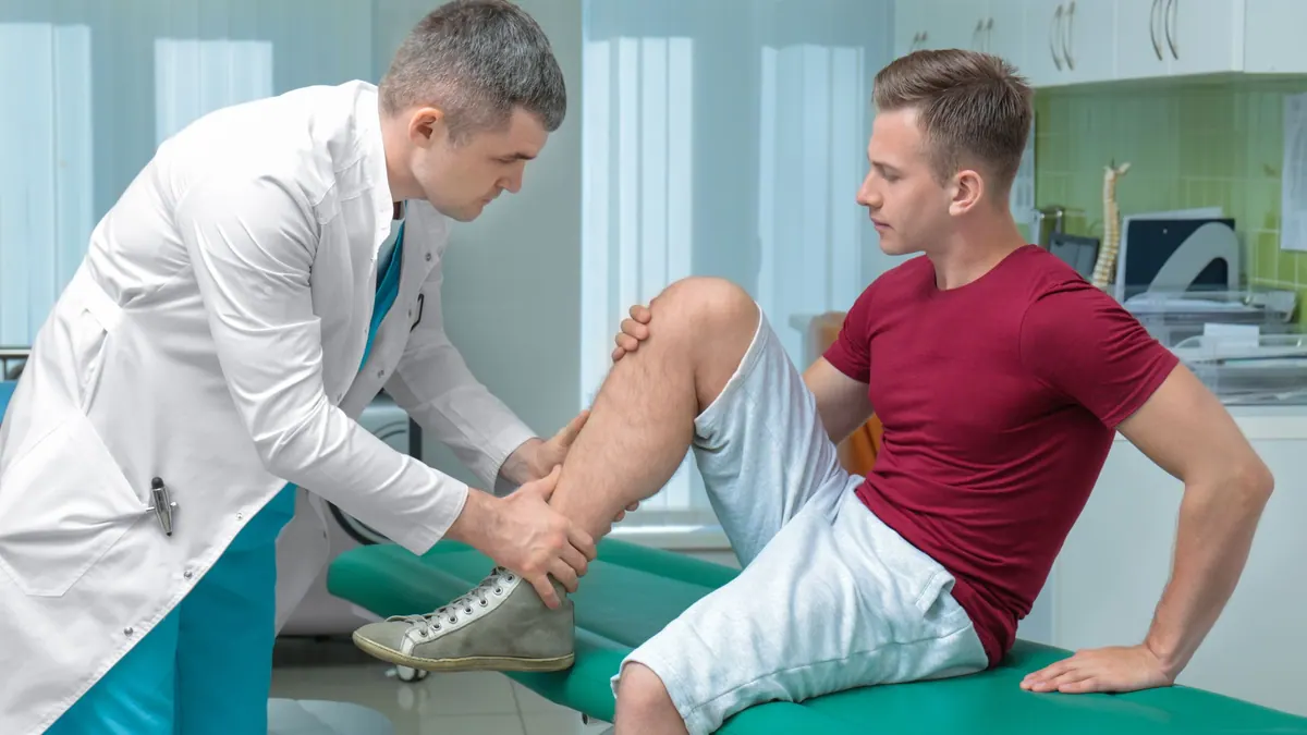 Fiziksel tıp ve rehabilitasyon neye bakar: hekim klinikte hastanın bacağını muayene ediyor